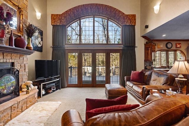 living room with carpet floors, a towering ceiling, and french doors