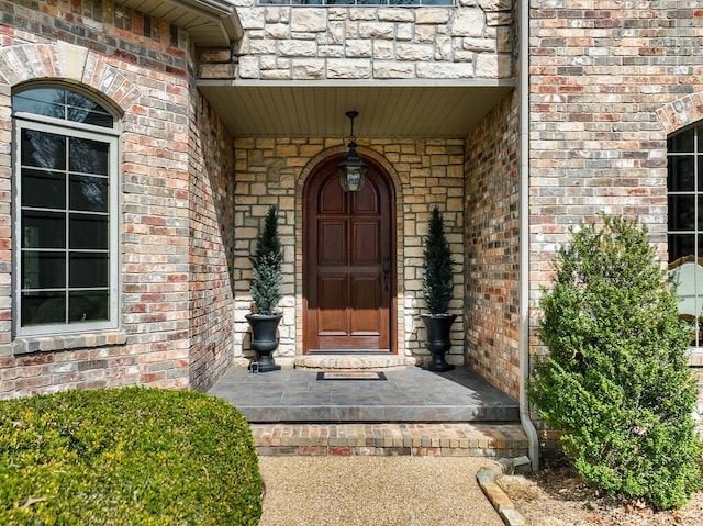 view of exterior entry featuring brick siding