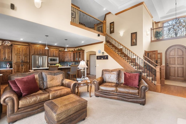 carpeted living area with arched walkways, a high ceiling, stairs, and ornamental molding