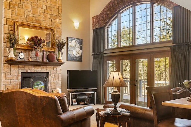 living room with a fireplace and a towering ceiling