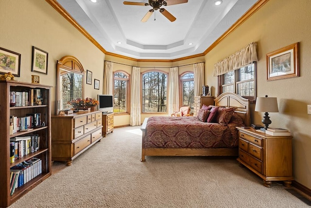 bedroom with a tray ceiling, visible vents, ornamental molding, light carpet, and baseboards