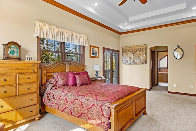 bedroom featuring baseboards, arched walkways, a raised ceiling, light colored carpet, and access to exterior