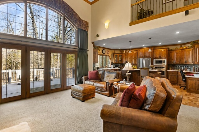 living area featuring light carpet, a high ceiling, ornamental molding, and recessed lighting