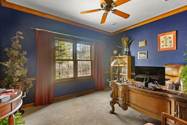 carpeted office space featuring ornamental molding and a ceiling fan