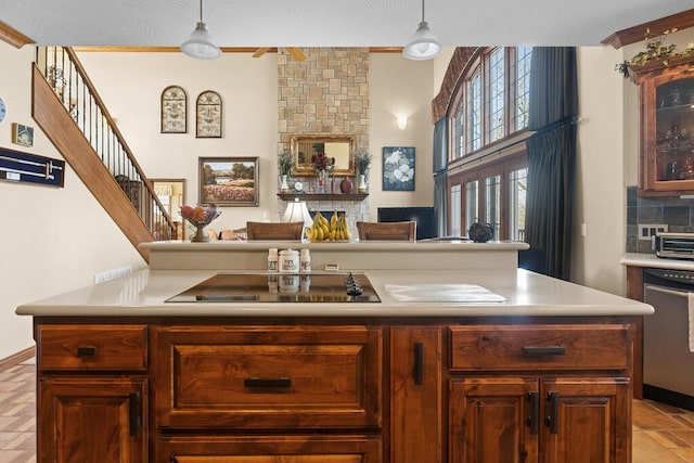 kitchen with black electric stovetop, light countertops, hanging light fixtures, stainless steel dishwasher, and decorative backsplash