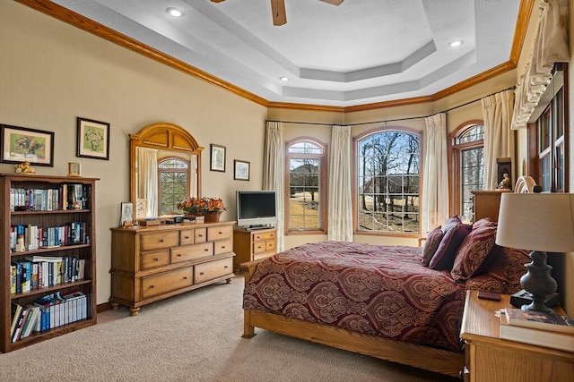 bedroom with crown molding, multiple windows, a raised ceiling, and light colored carpet