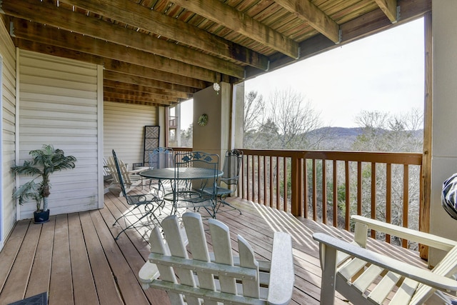 deck featuring outdoor dining area and a mountain view