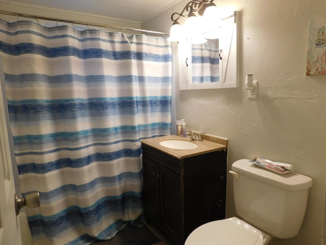 bathroom with a textured wall, curtained shower, vanity, and toilet