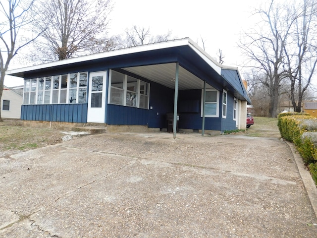 mid-century home with concrete driveway and an attached carport