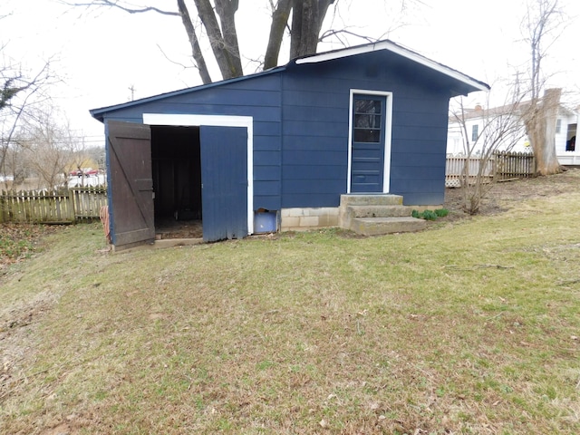 view of outbuilding featuring entry steps, an outdoor structure, and fence