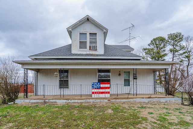 farmhouse-style home featuring a porch and a shingled roof