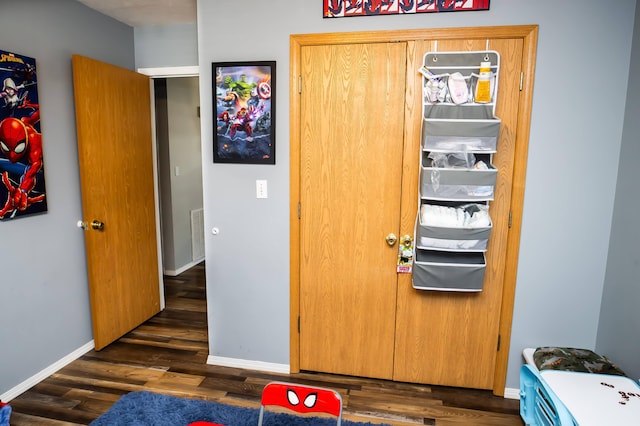 bedroom featuring a closet, dark wood-style flooring, visible vents, and baseboards