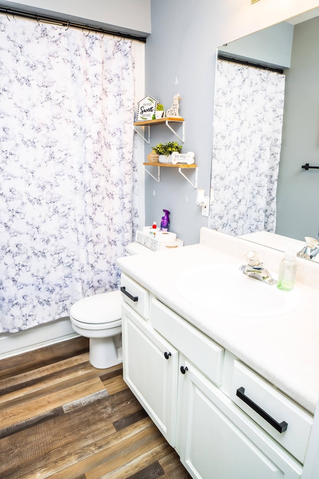 bathroom with a shower with curtain, vanity, toilet, and wood finished floors