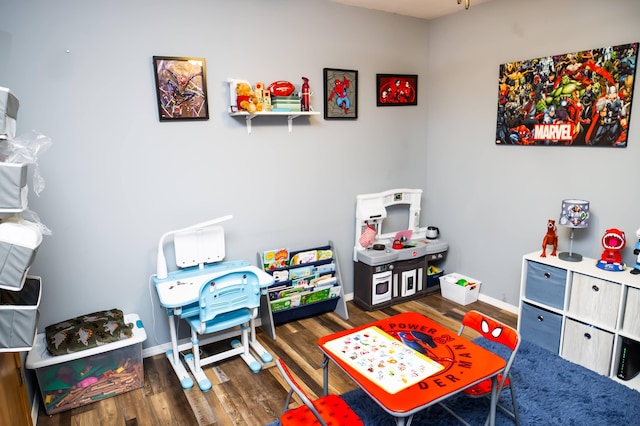 recreation room featuring baseboards and wood finished floors