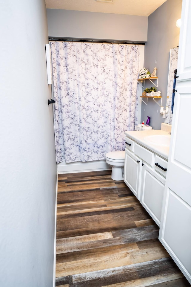 bathroom featuring a shower with curtain, vanity, toilet, and wood finished floors