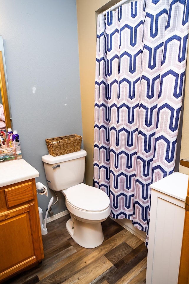 full bathroom with toilet, a shower with curtain, wood finished floors, and vanity