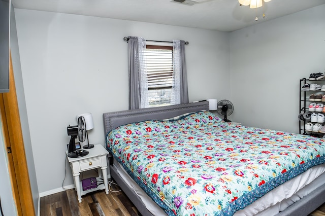 bedroom featuring dark wood-type flooring, a ceiling fan, visible vents, and baseboards