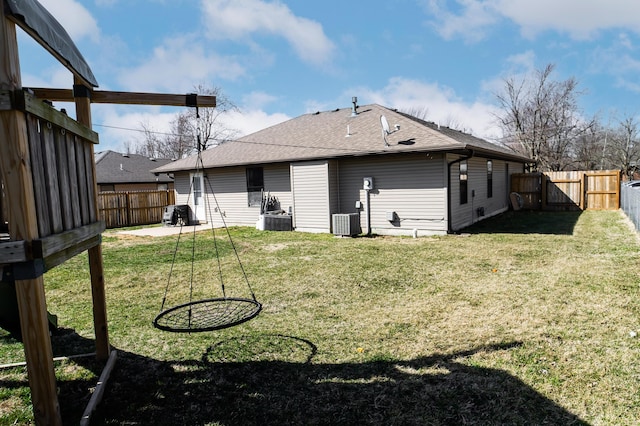 back of property featuring a fenced backyard, a shingled roof, a lawn, and cooling unit