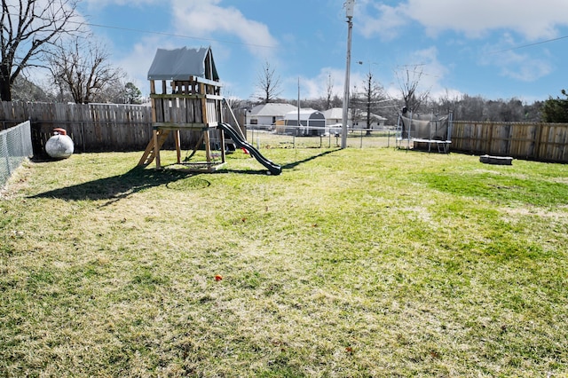 view of playground featuring a trampoline, a fenced backyard, and a lawn