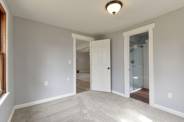 unfurnished bedroom with ensuite bath, carpet flooring, and baseboards