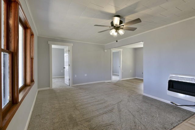 carpeted empty room with crown molding, a fireplace, baseboards, and heating unit