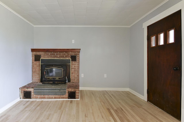 unfurnished living room with crown molding, visible vents, baseboards, and wood finished floors