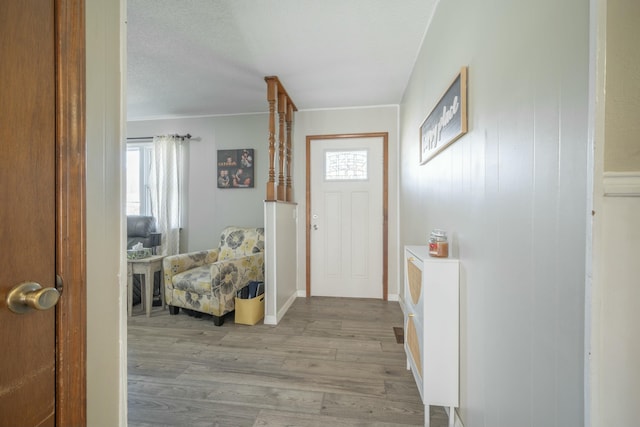 foyer entrance featuring a healthy amount of sunlight, light wood-style flooring, and a textured ceiling