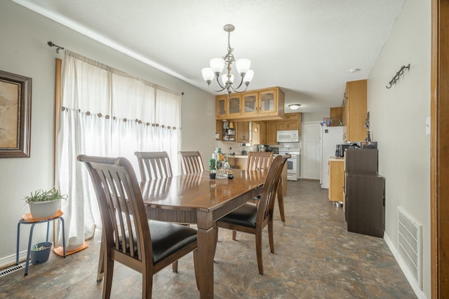 dining area featuring visible vents, a textured ceiling, baseboards, and an inviting chandelier