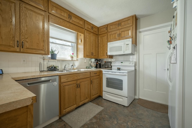 kitchen with white appliances, a sink, light countertops, decorative backsplash, and brown cabinets