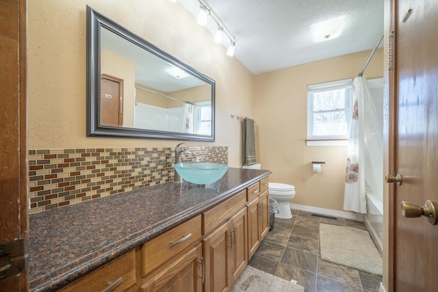 bathroom featuring a textured ceiling, toilet, vanity, baseboards, and decorative backsplash