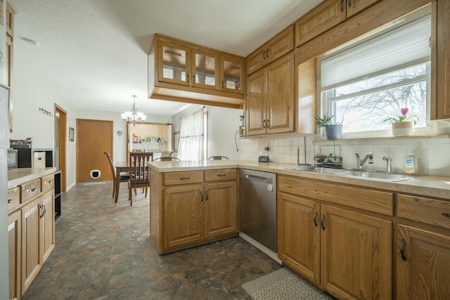 kitchen with a sink, a wealth of natural light, light countertops, and dishwasher