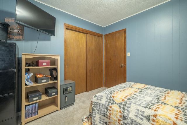 carpeted bedroom featuring a textured ceiling, a closet, and crown molding