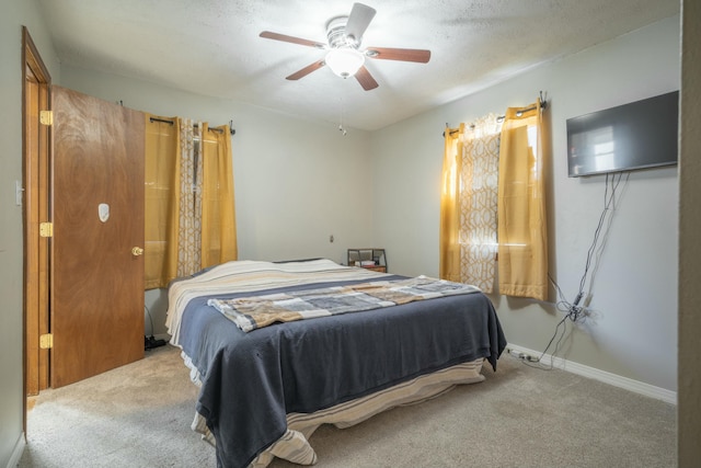 bedroom featuring ceiling fan, carpet floors, a textured ceiling, and baseboards