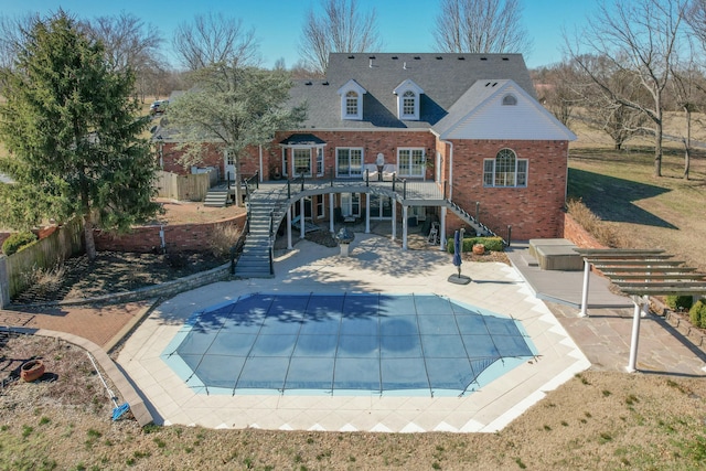 back of house with a fenced in pool, brick siding, a patio, a deck, and stairs