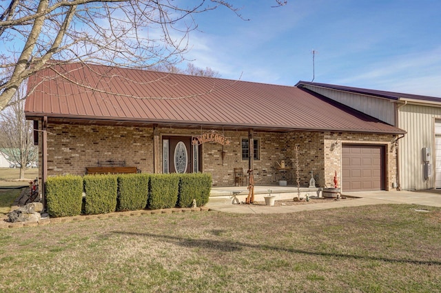 view of front of house featuring a garage, metal roof, and brick siding