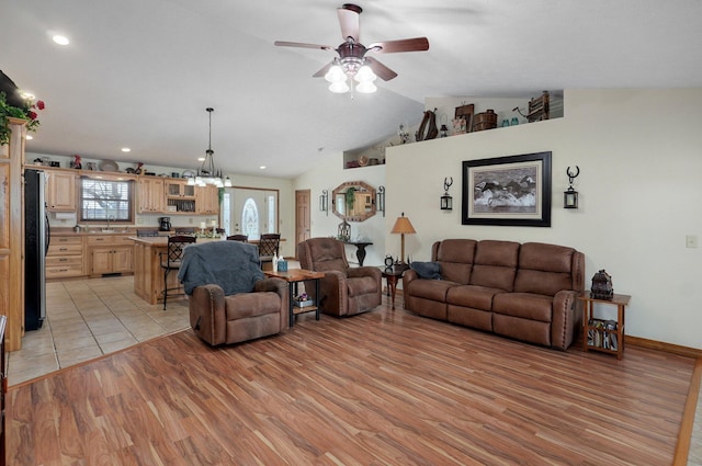 living area featuring vaulted ceiling, ceiling fan with notable chandelier, light wood-type flooring, and recessed lighting