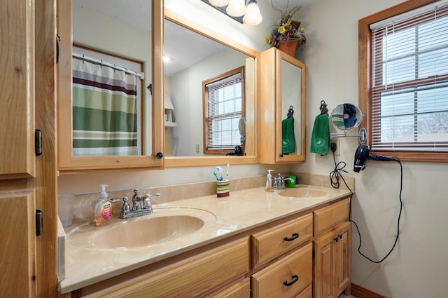 bathroom featuring a wealth of natural light, a sink, and double vanity