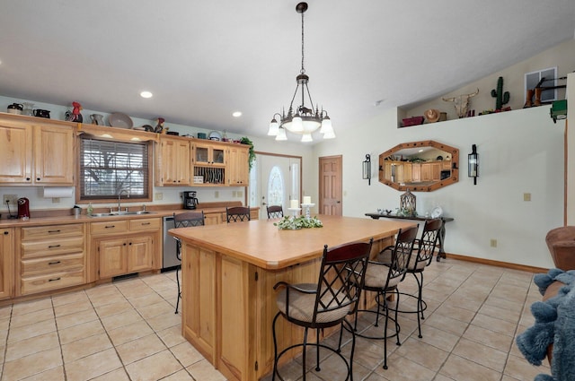 kitchen featuring light tile patterned flooring, a breakfast bar, a sink, and light brown cabinetry