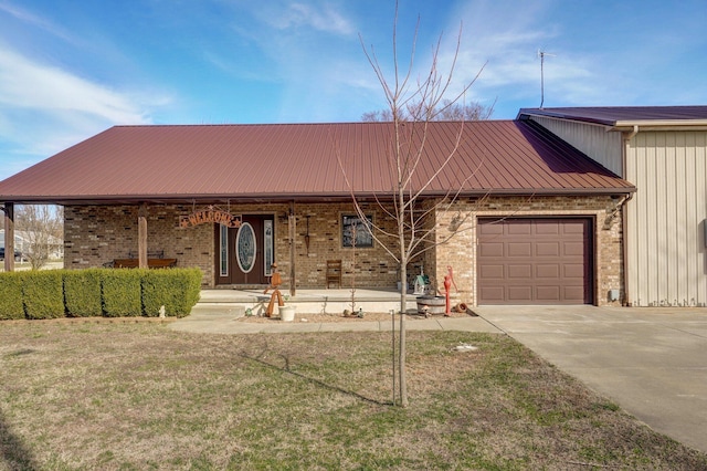 view of front of home featuring brick siding, covered porch, an attached garage, metal roof, and driveway