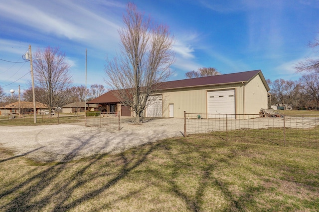 view of front of home with a detached garage, fence, and a front yard