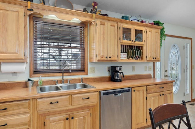 kitchen with glass insert cabinets, light countertops, stainless steel dishwasher, light brown cabinets, and a sink