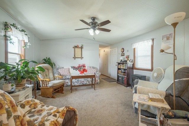 carpeted living area with ceiling fan and vaulted ceiling