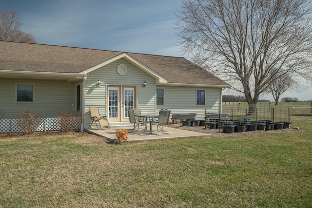 rear view of property with french doors, a patio area, a yard, and fence