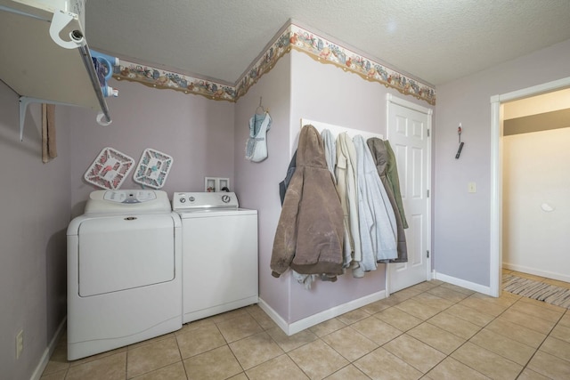 laundry area featuring laundry area, light tile patterned floors, baseboards, a textured ceiling, and separate washer and dryer