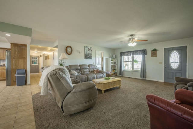 living area with light tile patterned flooring, a ceiling fan, and baseboards