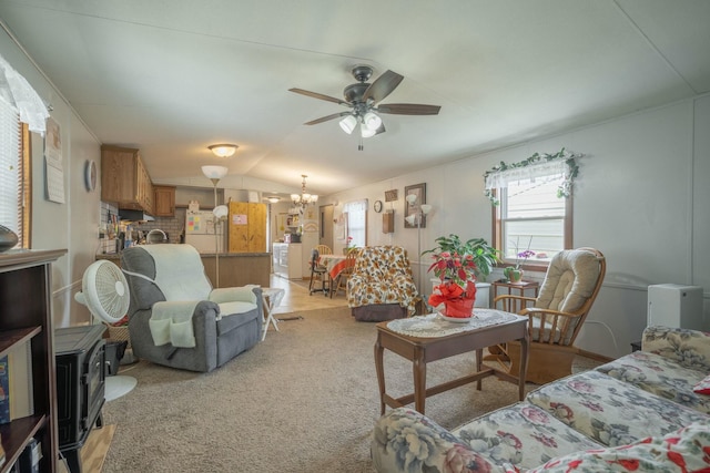 living area featuring vaulted ceiling and ceiling fan with notable chandelier