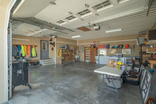 garage featuring a garage door opener, a sink, and a workshop area