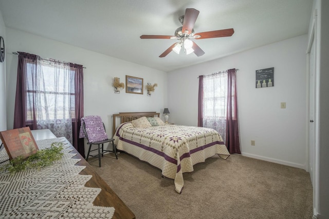 carpeted bedroom with a ceiling fan and baseboards