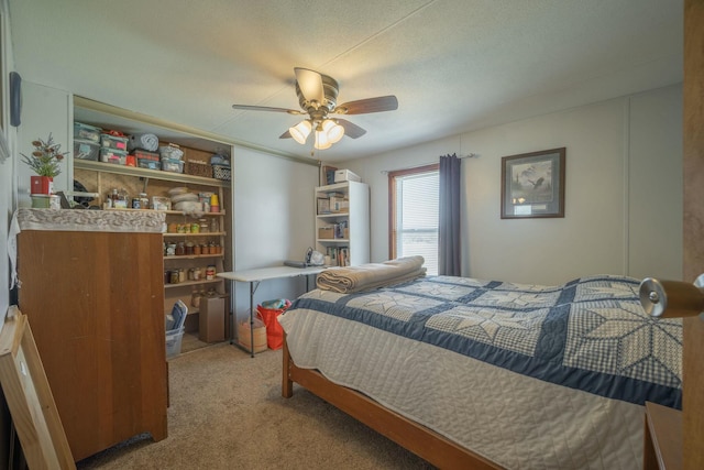 carpeted bedroom with ceiling fan and a textured ceiling