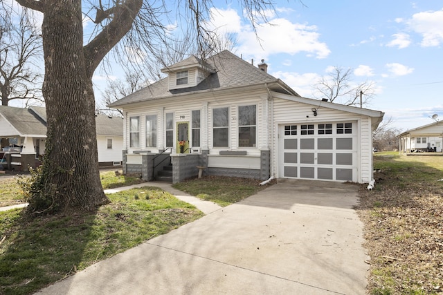 bungalow with a chimney, driveway, roof with shingles, and an attached garage